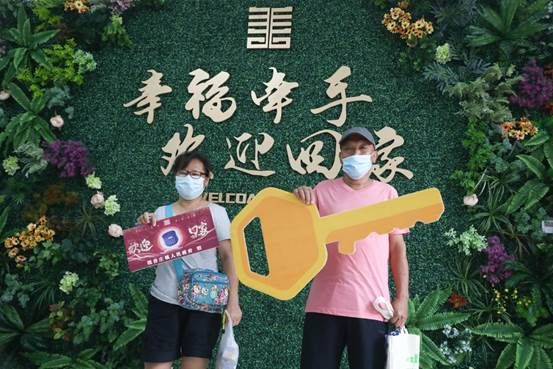 村民潘秀娟领到钥匙后在照片墙合影留念